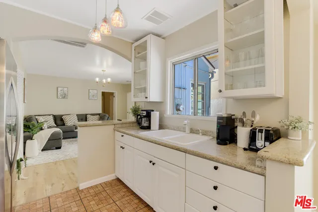 a kitchen with sink cabinets and living room view