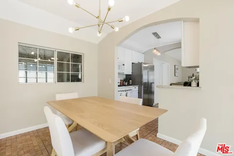 a kitchen with stainless steel appliances kitchen island a refrigerator sink and cabinets