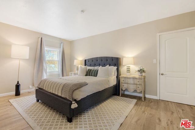 a bedroom with a bed and wooden floor