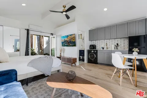 a spacious bedroom with a bed a couch and large window