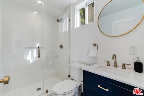 a bedroom with a bed and large windows