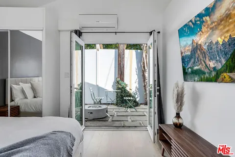 a patio with table and chairs and potted plants