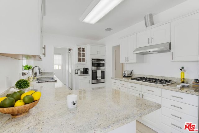 a kitchen with stainless steel appliances granite countertop a stove and a sink