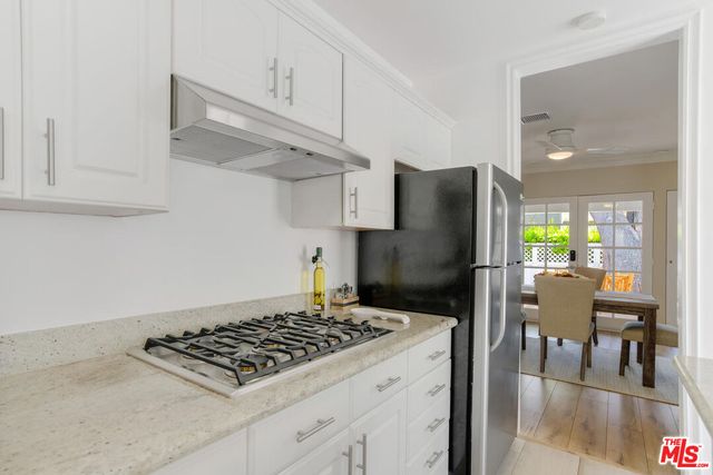 a kitchen with stainless steel appliances granite countertop a stove a refrigerator and a dining table