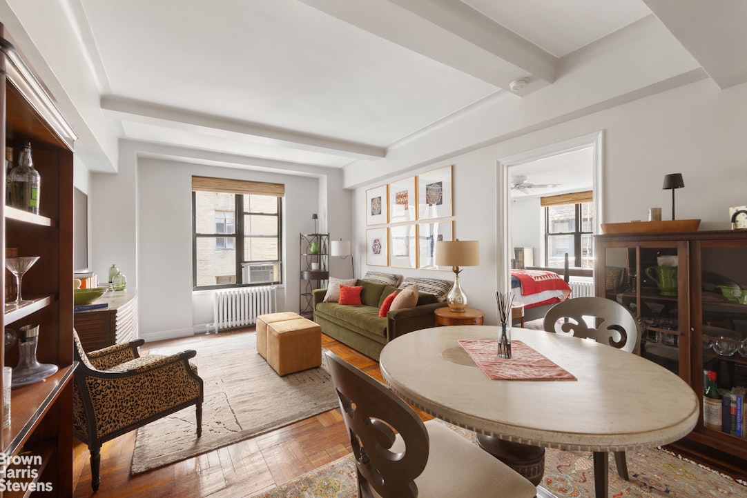 a living room with furniture a flat screen tv and a dining table