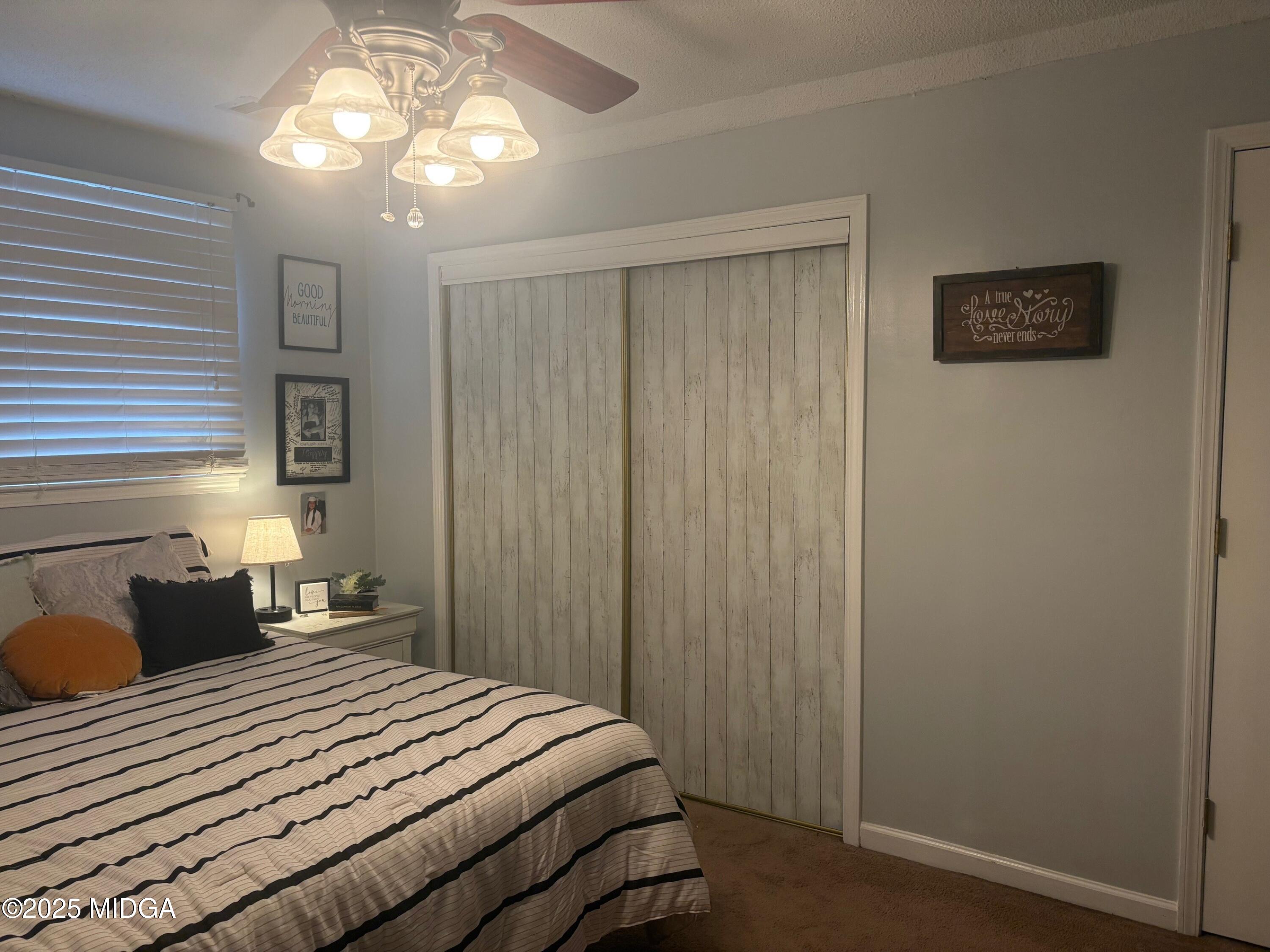 132 Old Hickory Road Byron, GA 31008 - Photo 16 of 35 a bedroom with a bed and a chandelier