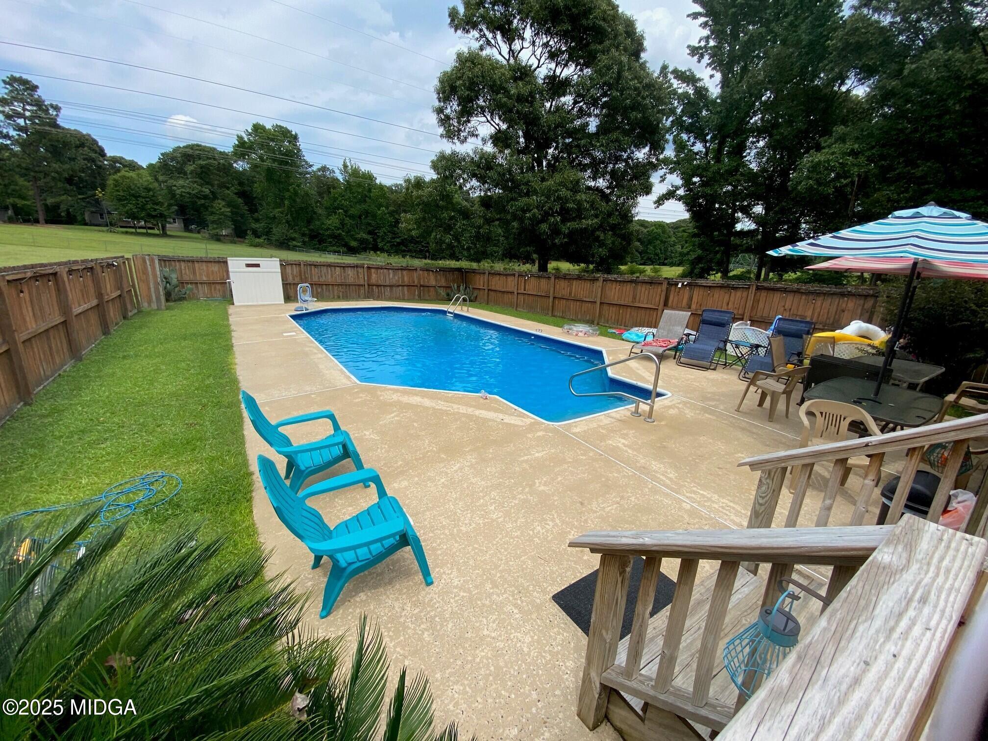 132 Old Hickory Road Byron, GA 31008 - Photo 26 of 35 a view of swimming pool with seating area and trees in the background