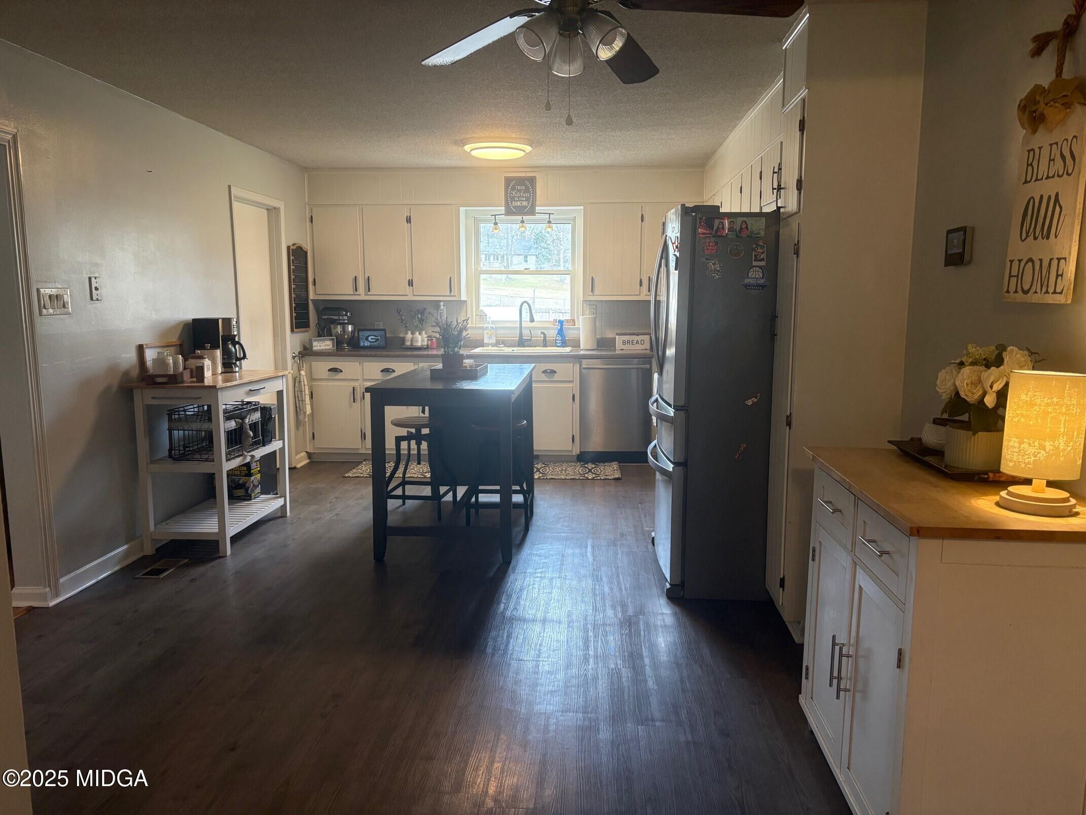 132 Old Hickory Road Byron, GA 31008 - Photo 4 of 35 a kitchen with a refrigerator a sink dishwasher a stove and a dining table with wooden floor