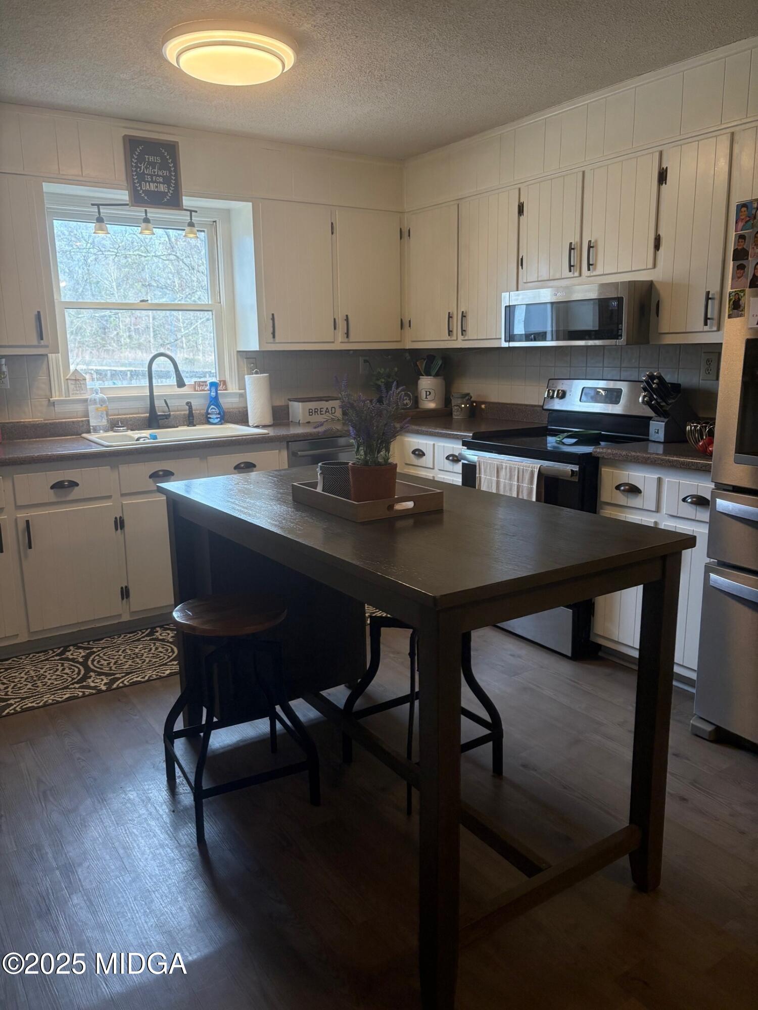 132 Old Hickory Road Byron, GA 31008 - Photo 5 of 35 a kitchen with a table chairs stove and cabinets
