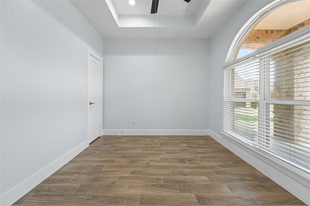 3807 Winding Road Arlington, TX 76016 - Photo 10 of 23 Spacious room featuring wood-finish tile flooring, a tray ceiling with recessed lighting, an arched transom window, and a ceiling fan