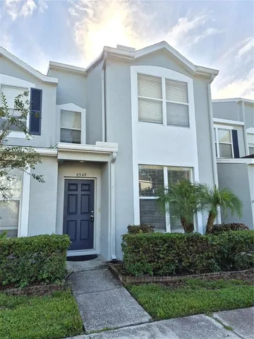 a front view of a house with plants and garden