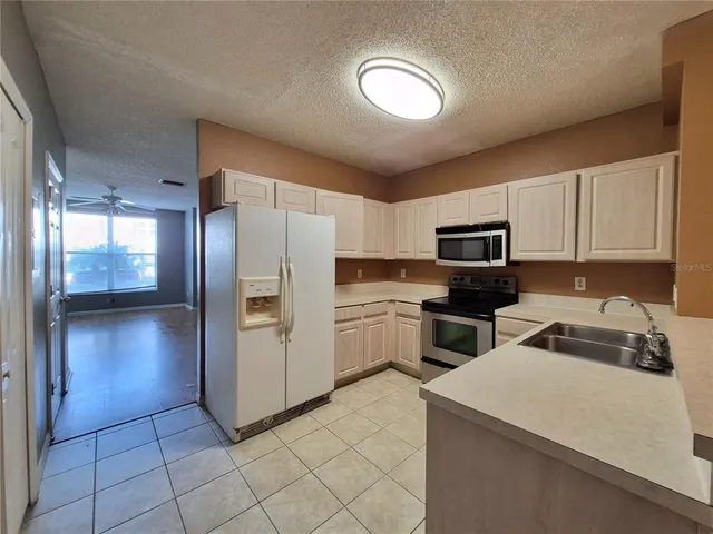 a kitchen with a refrigerator sink and cabinets