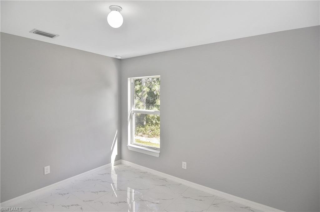 3306 1st Street Southwest Lehigh Acres, FL 33976 - Photo 13 of 47 an empty room with windows