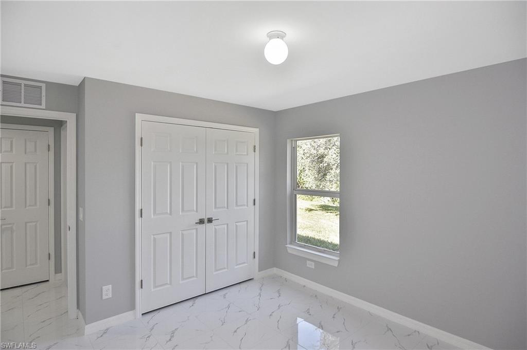 3306 1st Street Southwest Lehigh Acres, FL 33976 - Photo 17 of 47 an empty room with windows