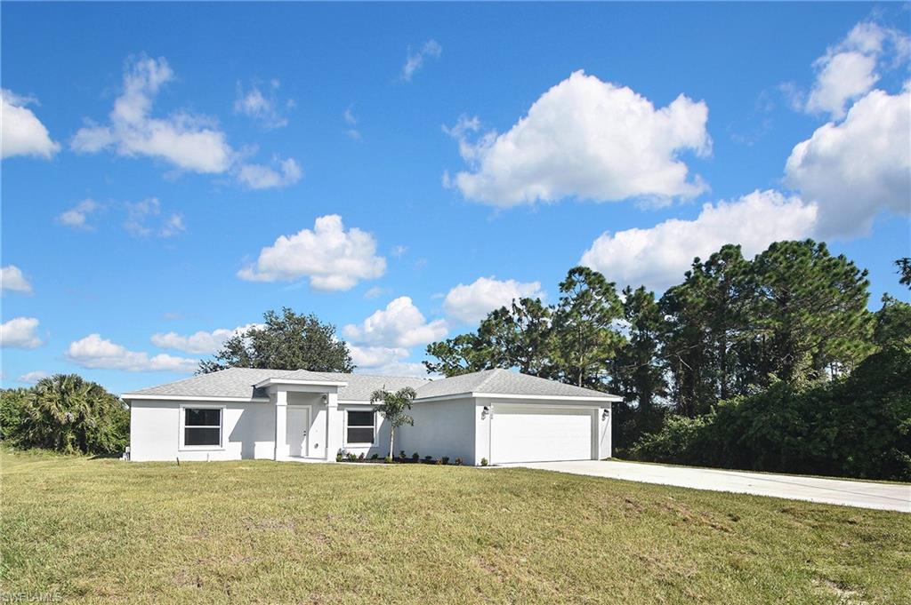 3306 1st Street Southwest Lehigh Acres, FL 33976 - Photo 2 of 47 a view of a house with a yard
