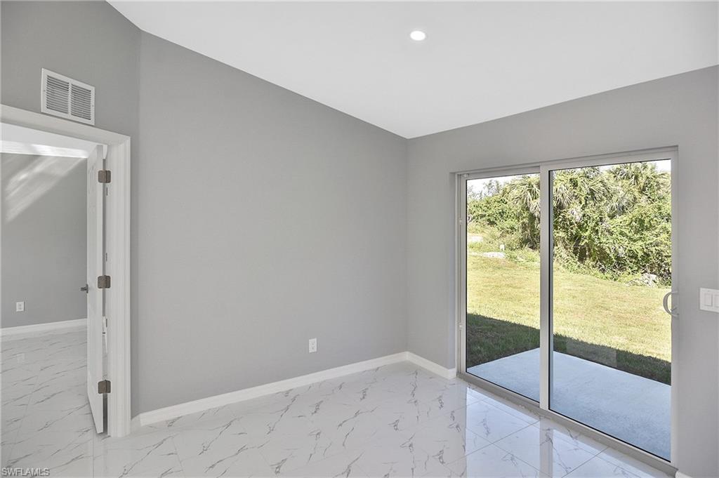 3306 1st Street Southwest Lehigh Acres, FL 33976 - Photo 22 of 47 a view of an empty room with glass door
