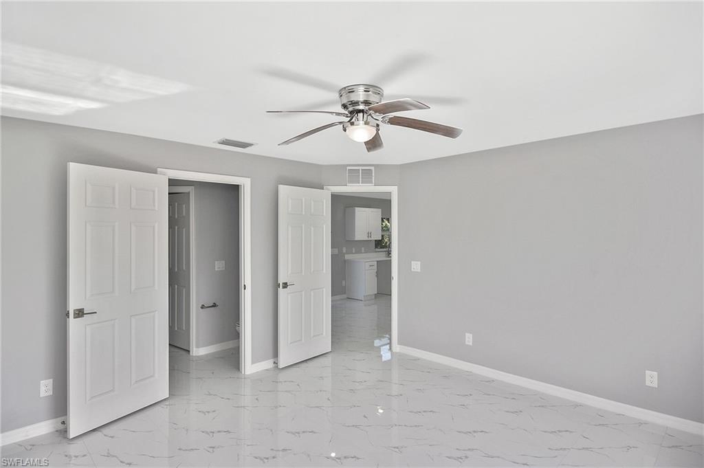 3306 1st Street Southwest Lehigh Acres, FL 33976 - Photo 26 of 47 wooden floor in an empty room with a window