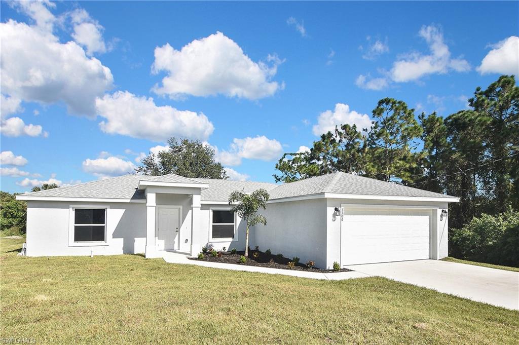 3306 1st Street Southwest Lehigh Acres, FL 33976 - Photo 3 of 47 a view of a house with a yard and garage