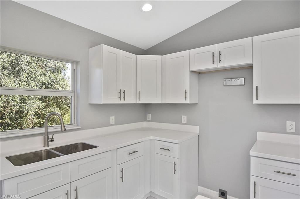 3306 1st Street Southwest Lehigh Acres, FL 33976 - Photo 36 of 47 a kitchen with white cabinets and a sink