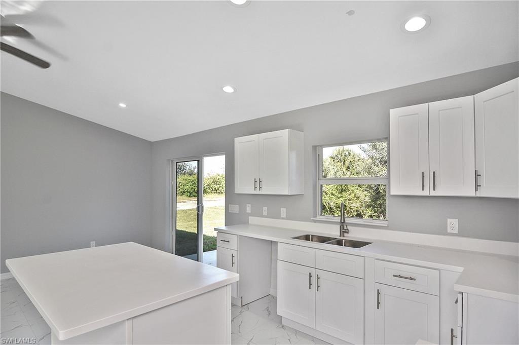 3306 1st Street Southwest Lehigh Acres, FL 33976 - Photo 37 of 47 a kitchen that has a sink and a stove in it