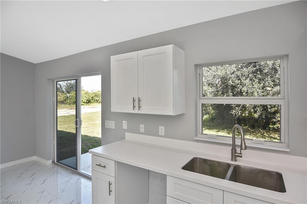 3306 1st Street Southwest Lehigh Acres, FL 33976 - Photo 39 of 47 a kitchen with a sink and large window