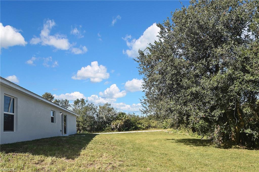 3306 1st Street Southwest Lehigh Acres, FL 33976 - Photo 44 of 47 a backyard of a house with lots of green space