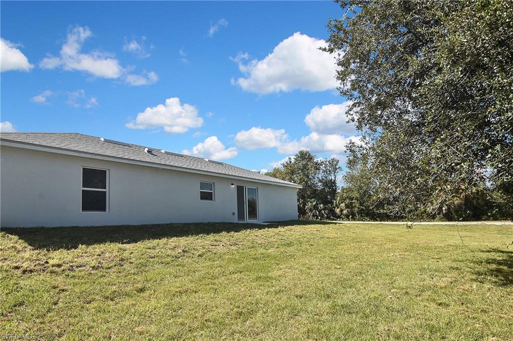 3306 1st Street Southwest Lehigh Acres, FL 33976 - Photo 46 of 47 a backyard of a house with lots of green space
