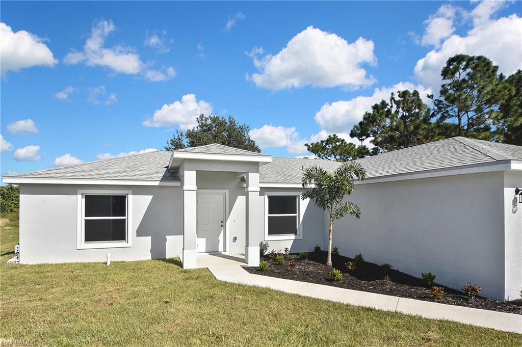 3306 1st Street Southwest Lehigh Acres, FL 33976 - Photo 5 of 47 a front view of a house with a yard