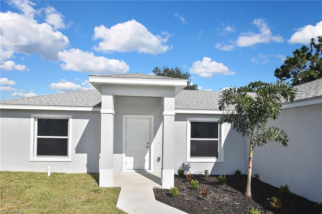 3306 1st Street Southwest Lehigh Acres, FL 33976 - Photo 6 of 47 a front view of a house with garden