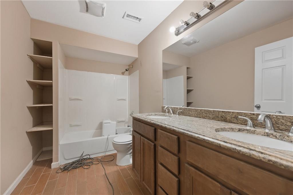 2139 Trailwood Road Decatur, GA 30032 - Photo 15 of 21 a bathroom with a granite countertop sink a toilet and a large mirror