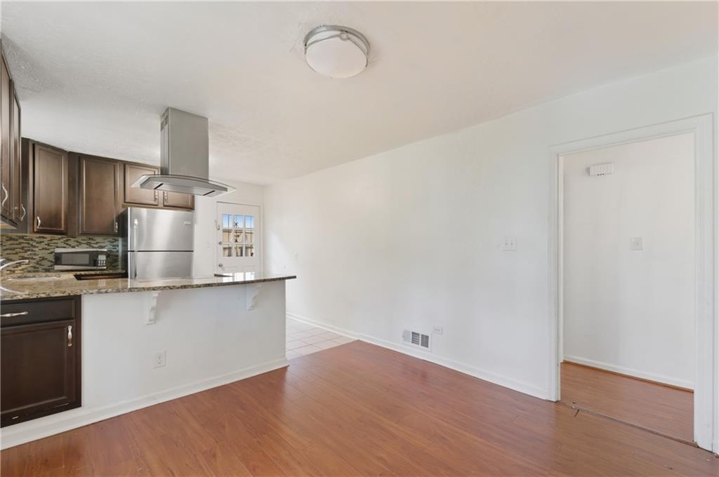2139 Trailwood Road Decatur, GA 30032 - Photo 7 of 21 a kitchen with cabinets wooden floor and stainless steel appliances