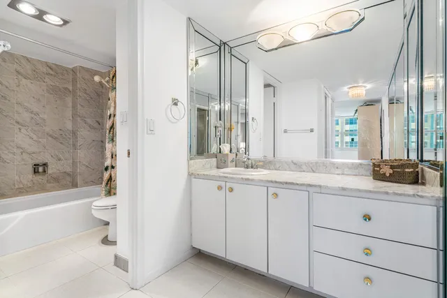 a bathroom with a granite countertop sink a toilet and bathtub