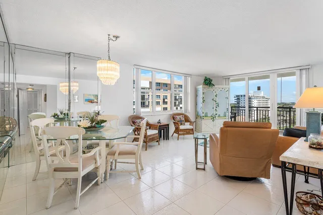 a living room with couches a dining table and chairs with wooden floor