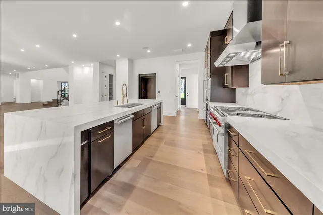 a large kitchen with stainless steel appliances granite countertop a large counter top a stove and a sink