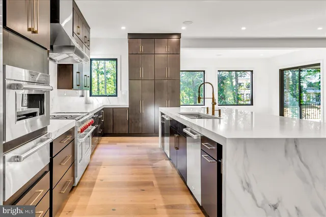 a kitchen with stainless steel appliances granite countertop a sink and a stove
