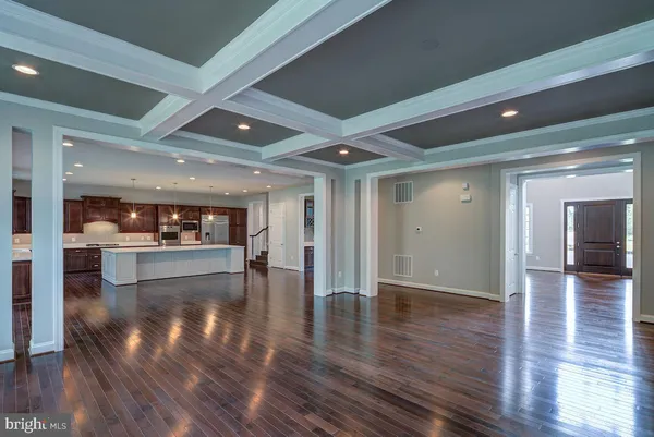 a view of a hallway with wooden floor and a refrigerator