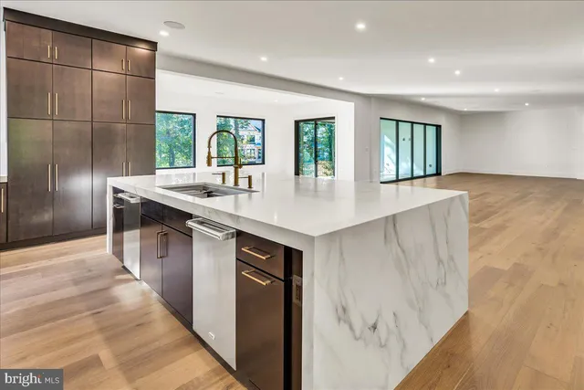 a kitchen with stainless steel appliances granite countertop a sink and a large window
