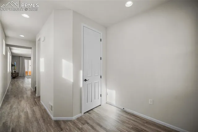 a view of a hallway with wooden floor