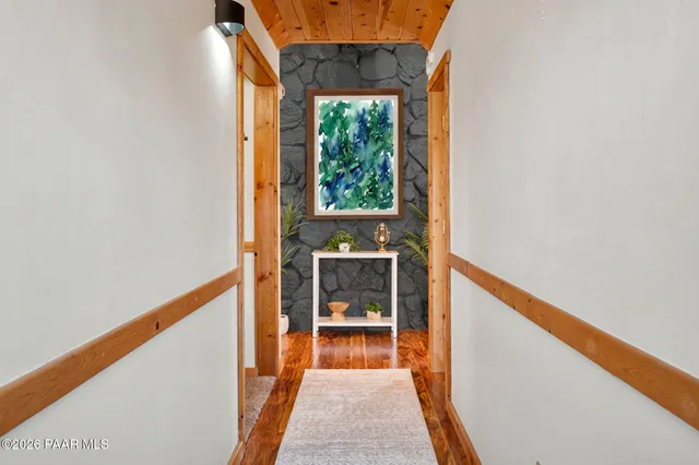 a view of a hallway with wooden floor and a window