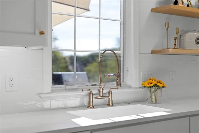 a kitchen with granite countertop a sink a stove and cabinets