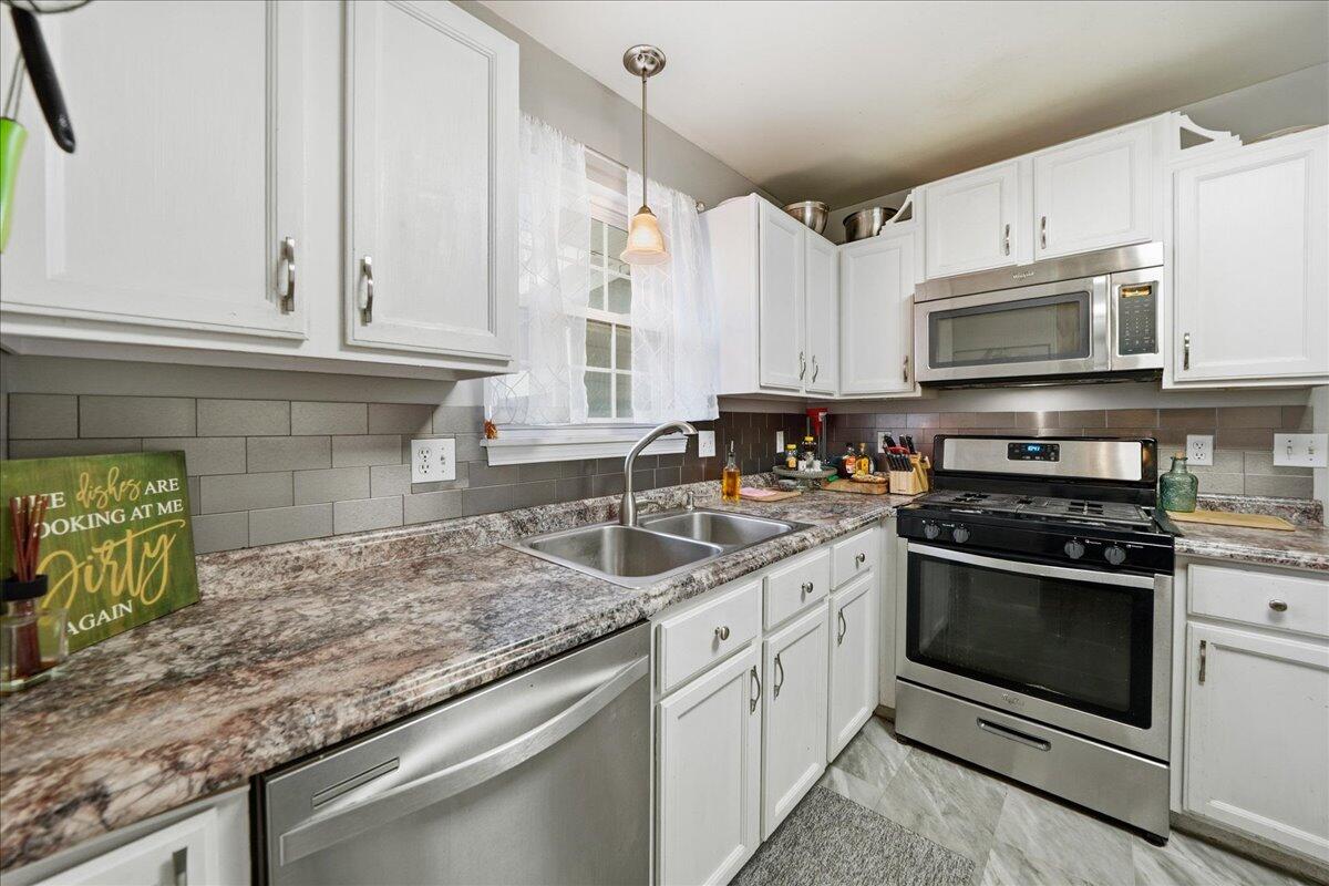 2258 Iris Street Portage, IN 46368 - Photo 11 of 29 a kitchen with granite countertop a sink stainless steel appliances and white cabinets
