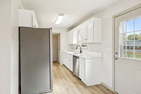 a kitchen with stainless steel appliances granite countertop a sink a stove a refrigerator a washer and dryer