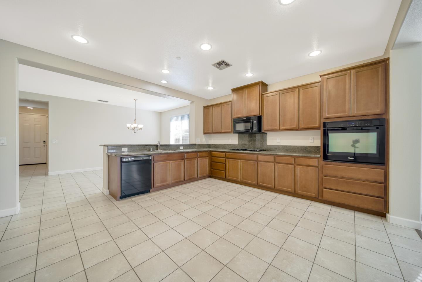 1479 Orgullo Lane Manteca, CA 95337 - Photo 14 of 39 a large kitchen with stainless steel appliances granite countertop a sink and cabinets