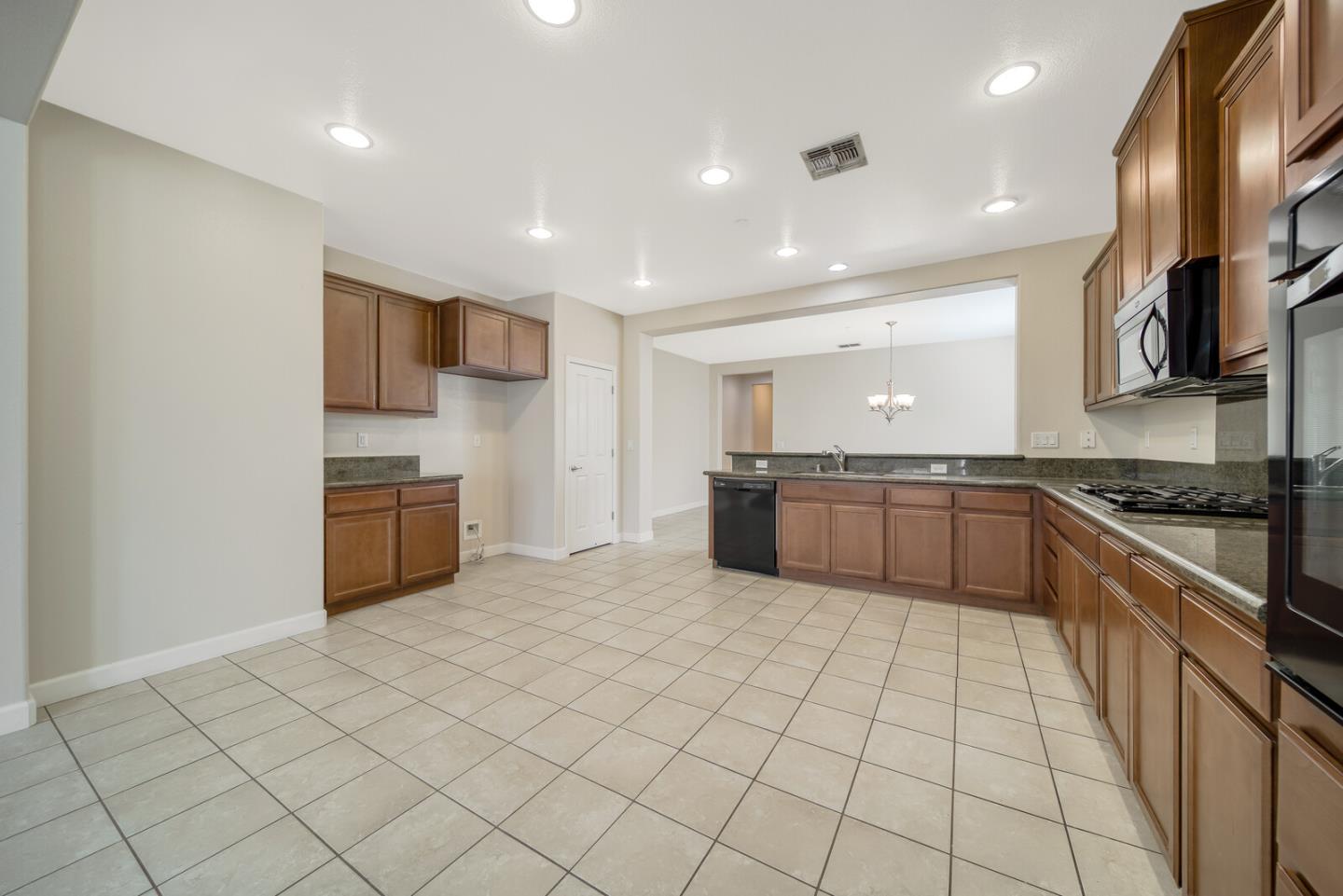 1479 Orgullo Lane Manteca, CA 95337 - Photo 15 of 39 a large kitchen with stainless steel appliances granite countertop a sink and cabinets