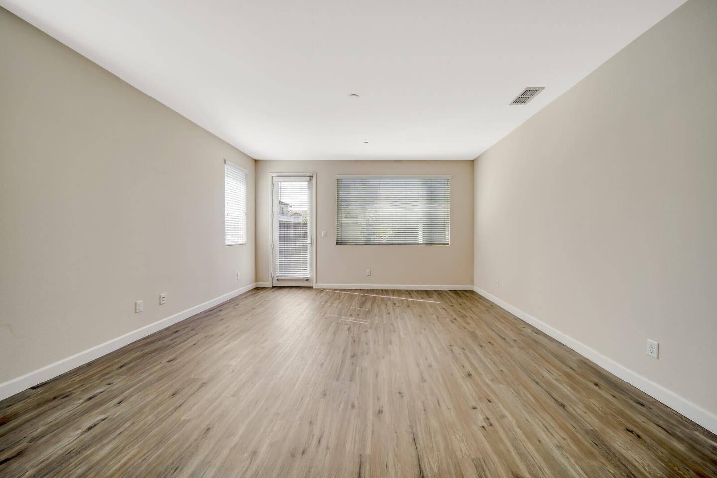 1479 Orgullo Lane Manteca, CA 95337 - Photo 16 of 39 an empty room with wooden floor and windows