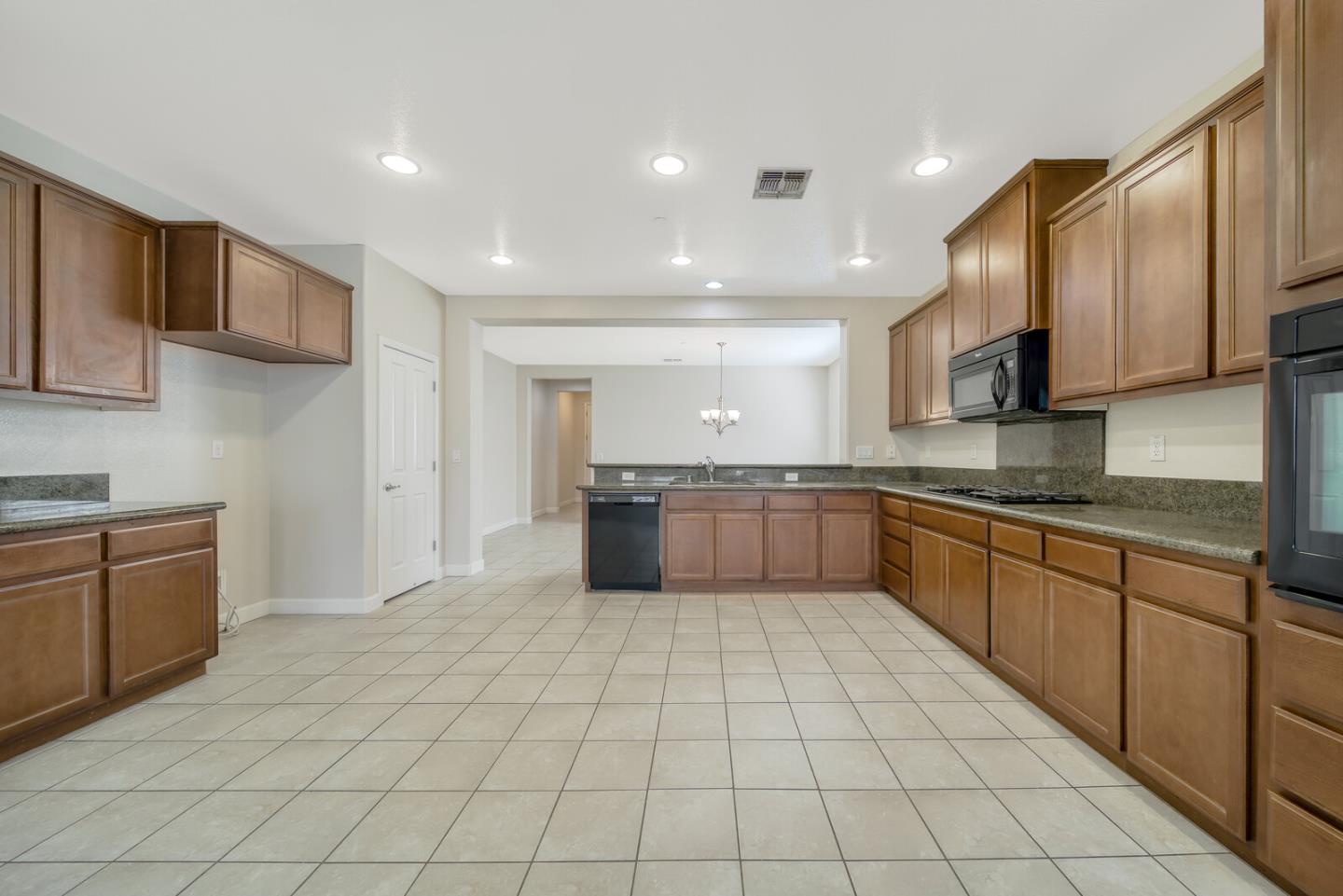 1479 Orgullo Lane Manteca, CA 95337 - Photo 3 of 39 a large kitchen with a large counter top space a sink stainless steel appliances and cabinets