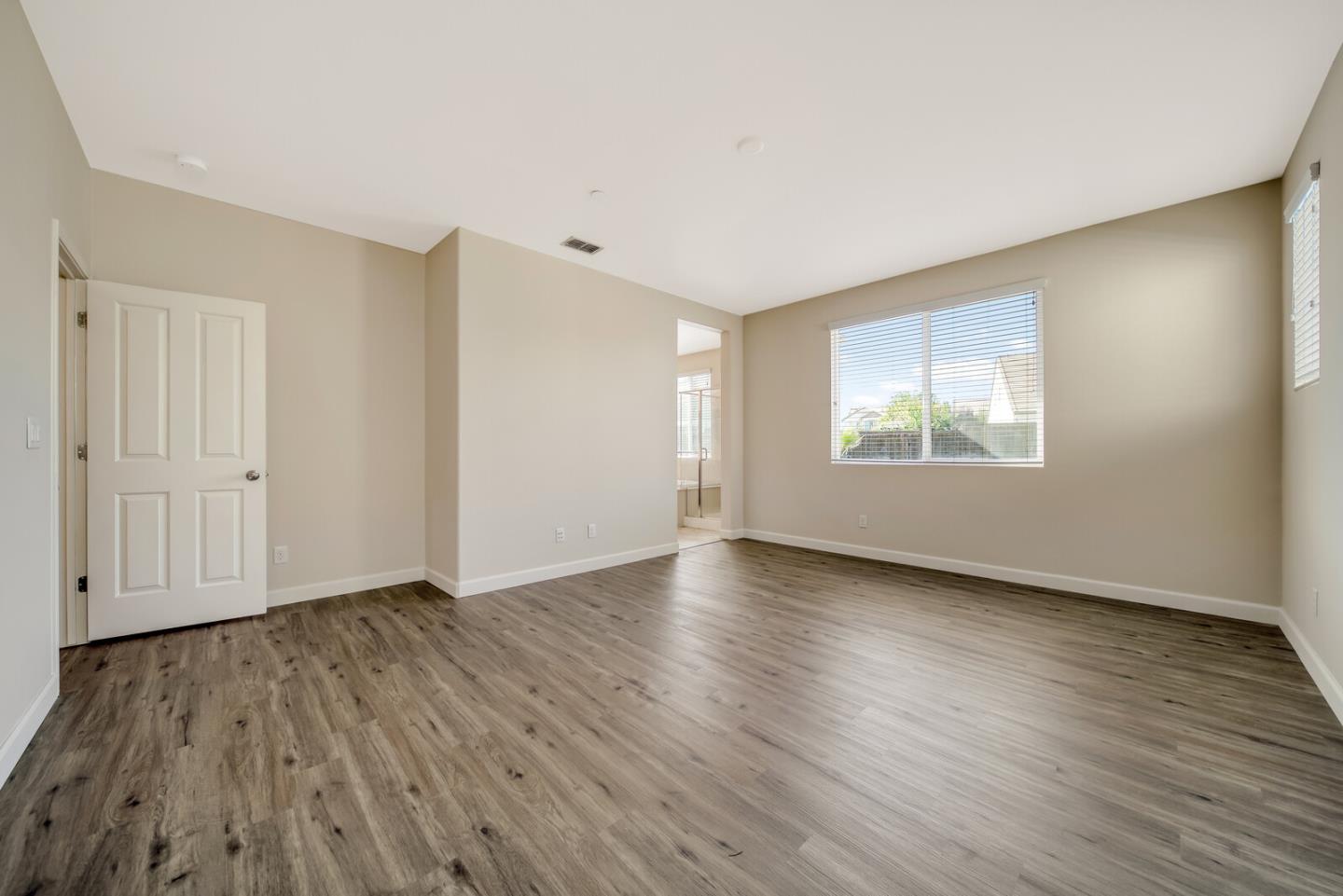 1479 Orgullo Lane Manteca, CA 95337 - Photo 28 of 39 an empty room with wooden floor and windows