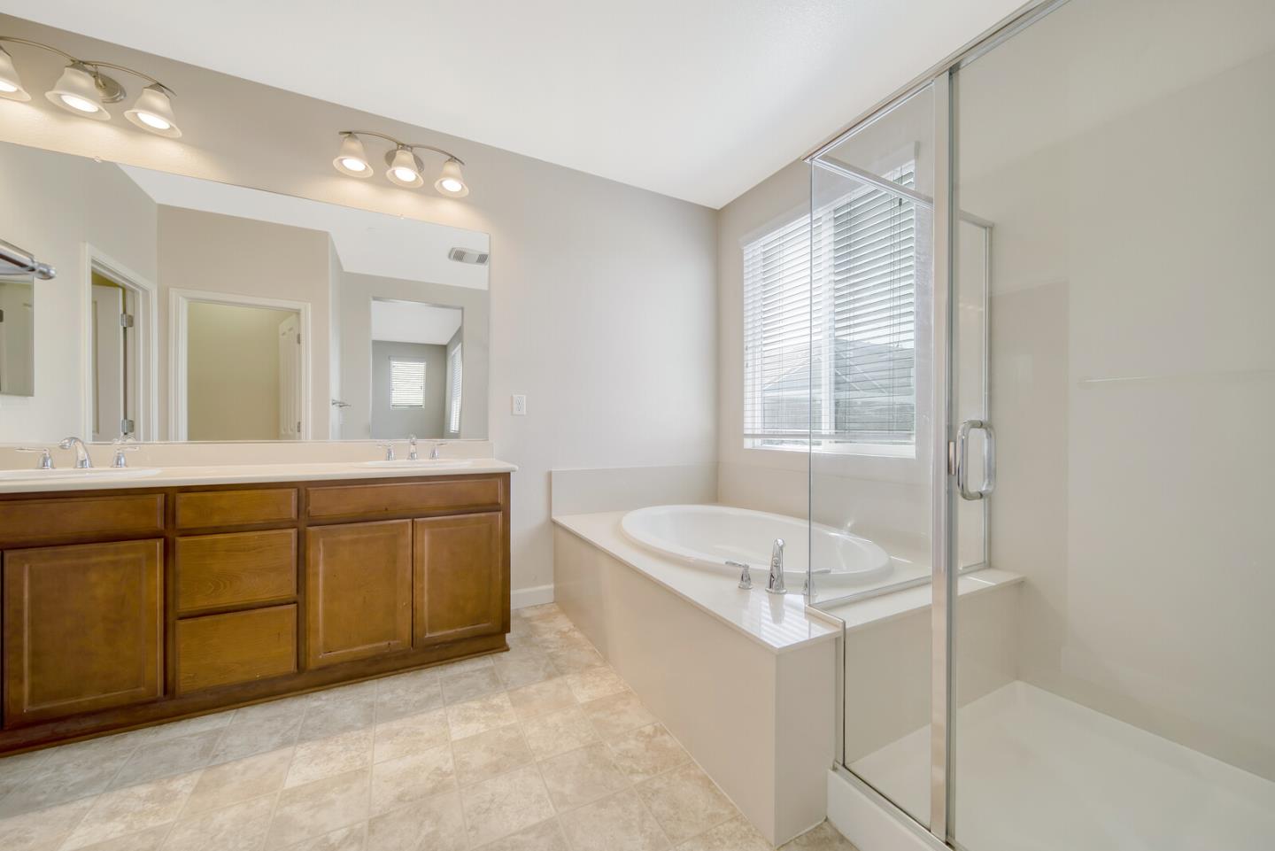1479 Orgullo Lane Manteca, CA 95337 - Photo 31 of 39 a spacious bathroom with a granite countertop sink and a mirror
