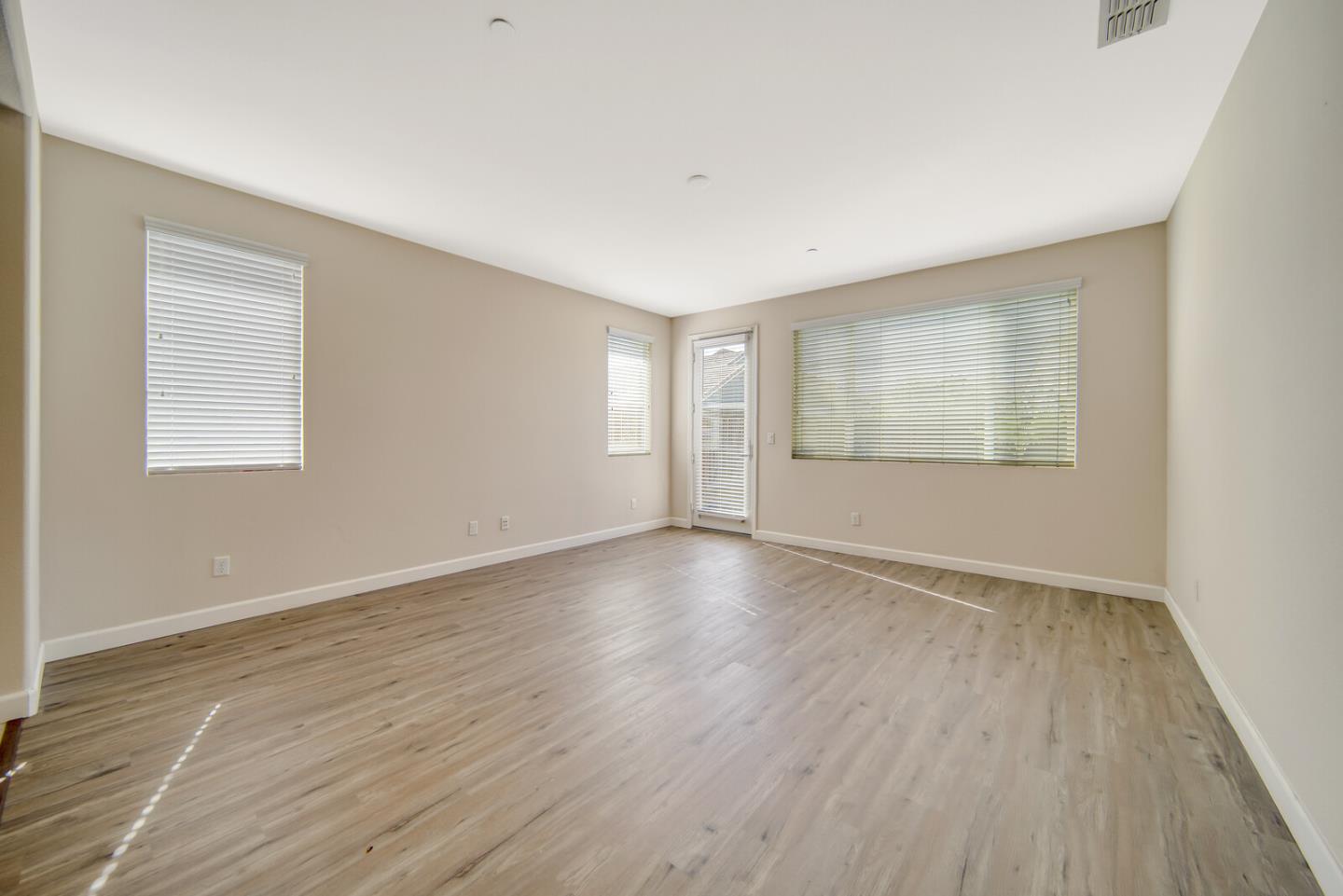 1479 Orgullo Lane Manteca, CA 95337 - Photo 5 of 39 an empty room with wooden floor and windows