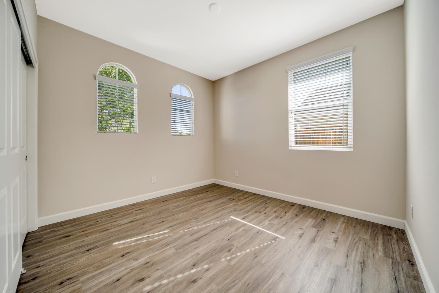 1479 Orgullo Lane Manteca, CA 95337 - Photo 7 of 39 an empty room with wooden floor and windows